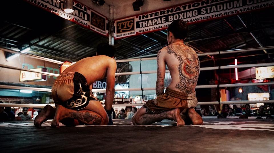 Two fighters kneeling in the ring before a bout